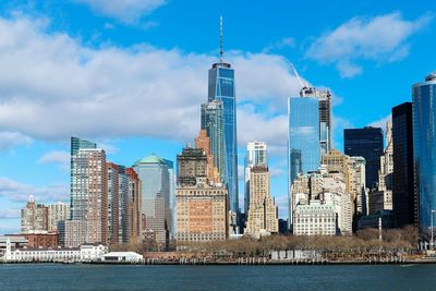 Skyscrapers in city against cloudy sky