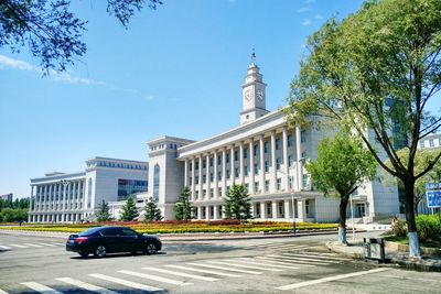 Car moving on road by university in city