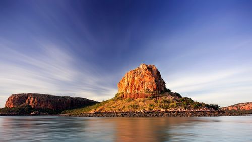 Rock formation in sea against sky