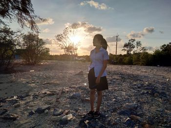Full length of woman standing on land against sky