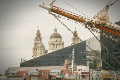 Ferris wheel by buildings against sky in city