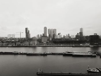 River by cityscape against sky