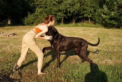 Side view of woman with dog on field