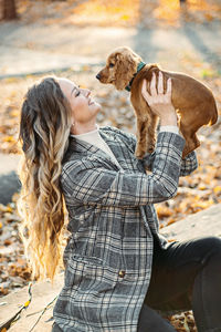 Caring for your pet in autumn, cute english cocker spaniel puppy walking with female owner in