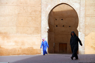 Full length of woman standing against wall