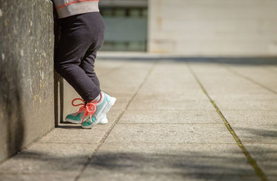 Low section of woman standing on footpath