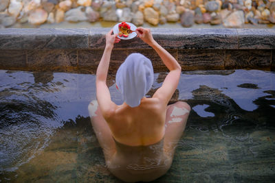 Low section of woman standing in water