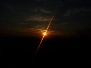 Silhouette of vapor trail in sky during sunset