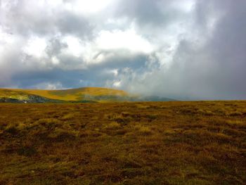 Scenic view of mountains against cloudy sky