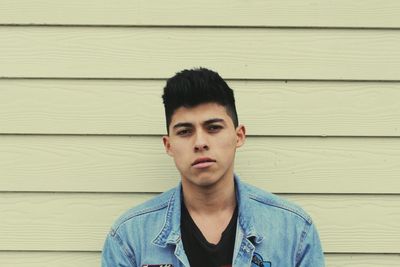 Portrait of handsome man against white wooden wall