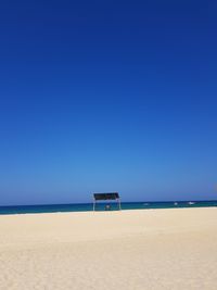 Scenic view of beach against clear blue sky