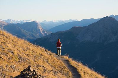 Rear view of man on mountain road against sky