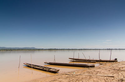 Boats moored in lake against sky