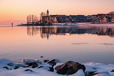 Reflection of buildings in city during sunset