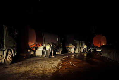 Rear view of people on illuminated street at night