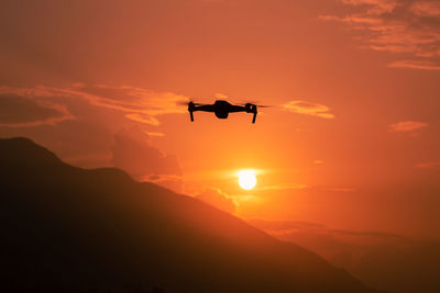 Low angle view of helicopter against sky during sunset