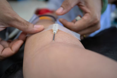 Close-up of doctor injecting syringe on patient hand