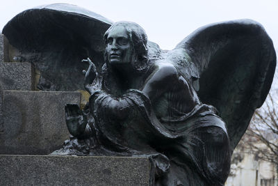 Statue against sky at cemetery