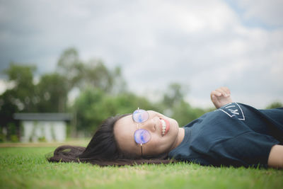 Portrait of girl lying on grassy field