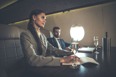 Business people sitting at table in airplane