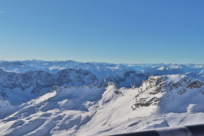 Scenic view of snowcapped mountains against clear blue sky