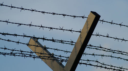 Low angle view of barbed wire against clear sky