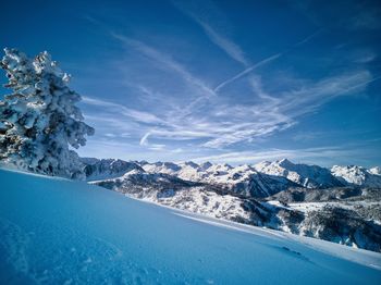 Aerial view of snowcapped mountains against blue sky