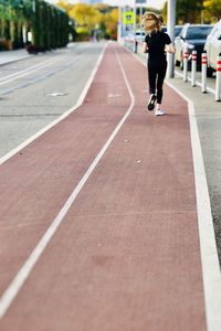 Rear view of woman running in city