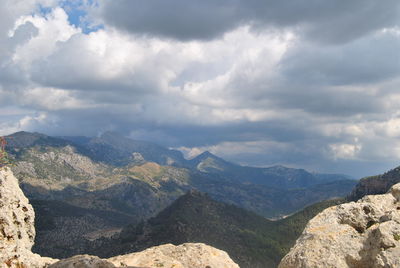 Scenic view of mountains against cloudy sky