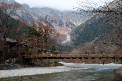 Bridge over river against mountains