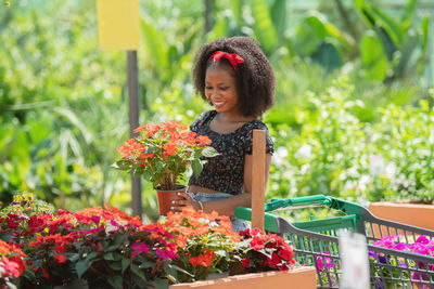 Smiling young woman looking at flowers at botany