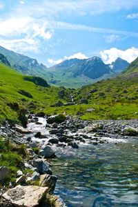 Scenic view of river and mountains against sky