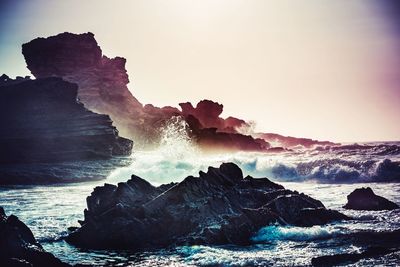 Scenic view of rocks in sea against sky