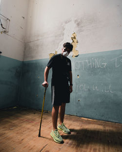 Full length of woman standing against wall