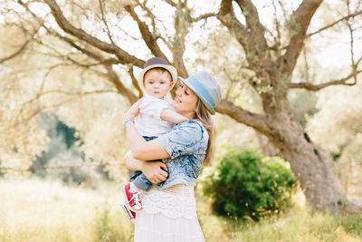 Mother and daughter standing on tree