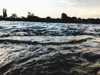 Surface level of sea against sky during sunset