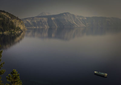 Scenic view of lake by mountains against sky