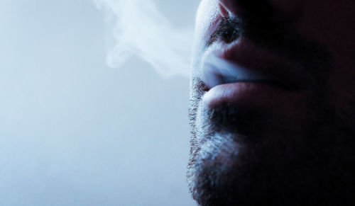 Close-up of man exhaling smoke