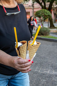 Midsection of woman holding ice cream cone