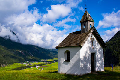 Building on field against sky