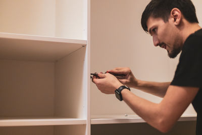 Side view of young man working at home