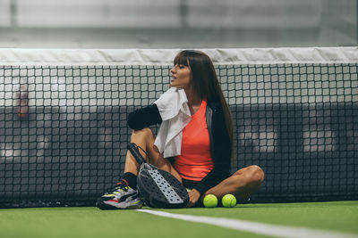Beautiful girl sitting after playing paddle tennis. young sporty woman at the end of the match. 