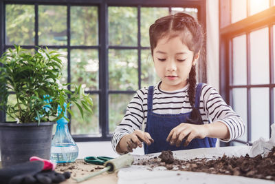 Girl looking through window at home