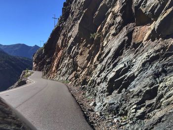 Scenic view of road by mountains against clear sky