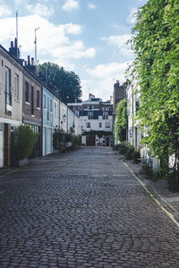 View of street amidst buildings in city against sky