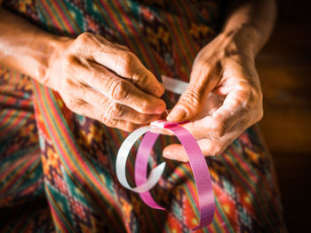 Midsection of woman holding ribbon