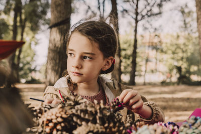 Portrait of girl looking through tree