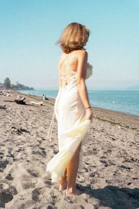 Rear view of woman standing at beach