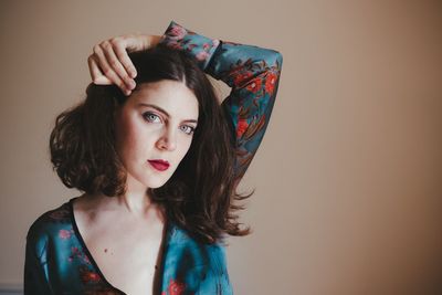 Portrait of young woman standing against white background