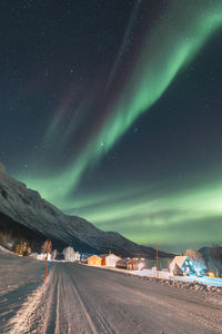 Illuminated road against sky at night
